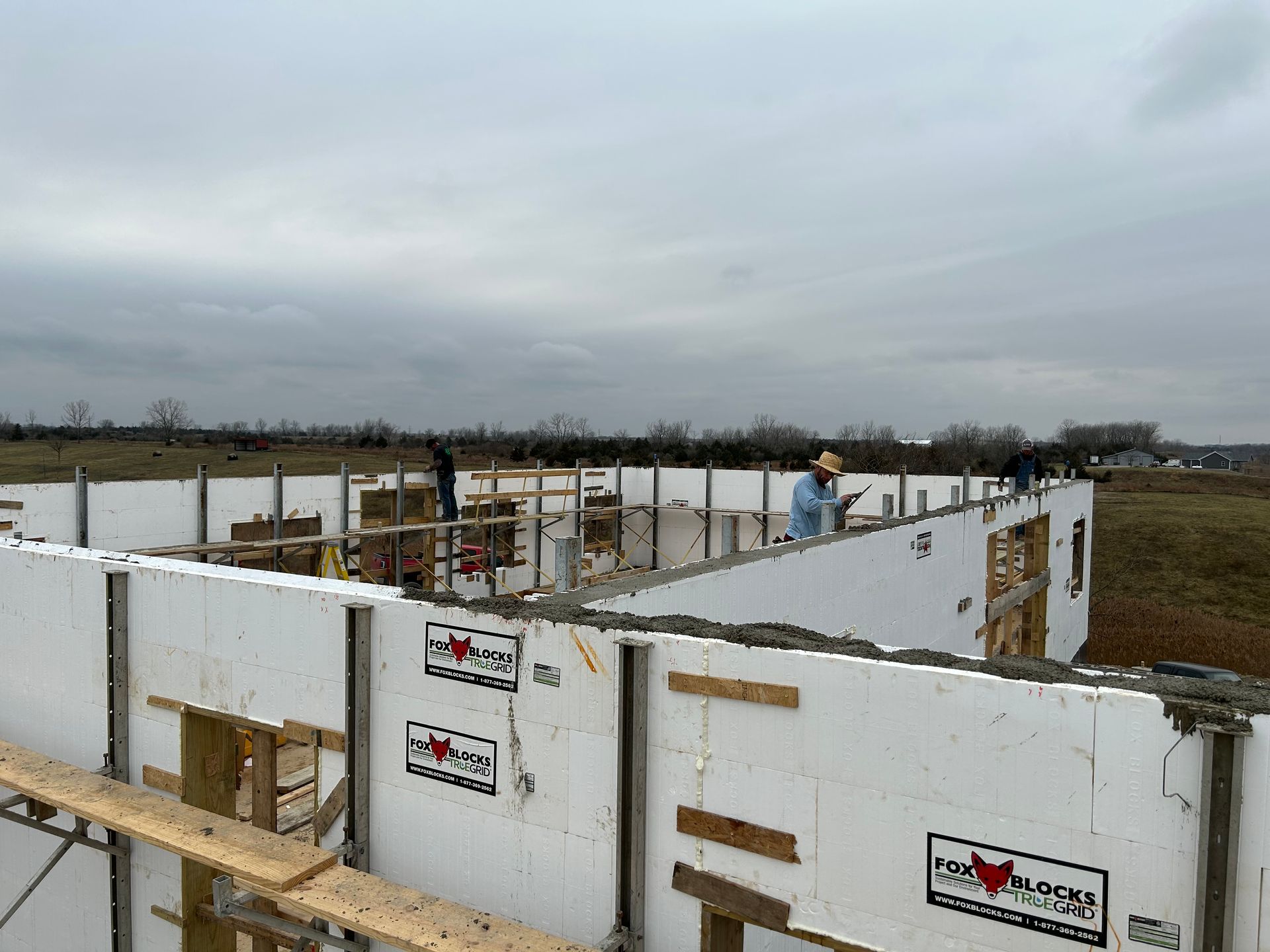 A man is standing on top of a building under construction.