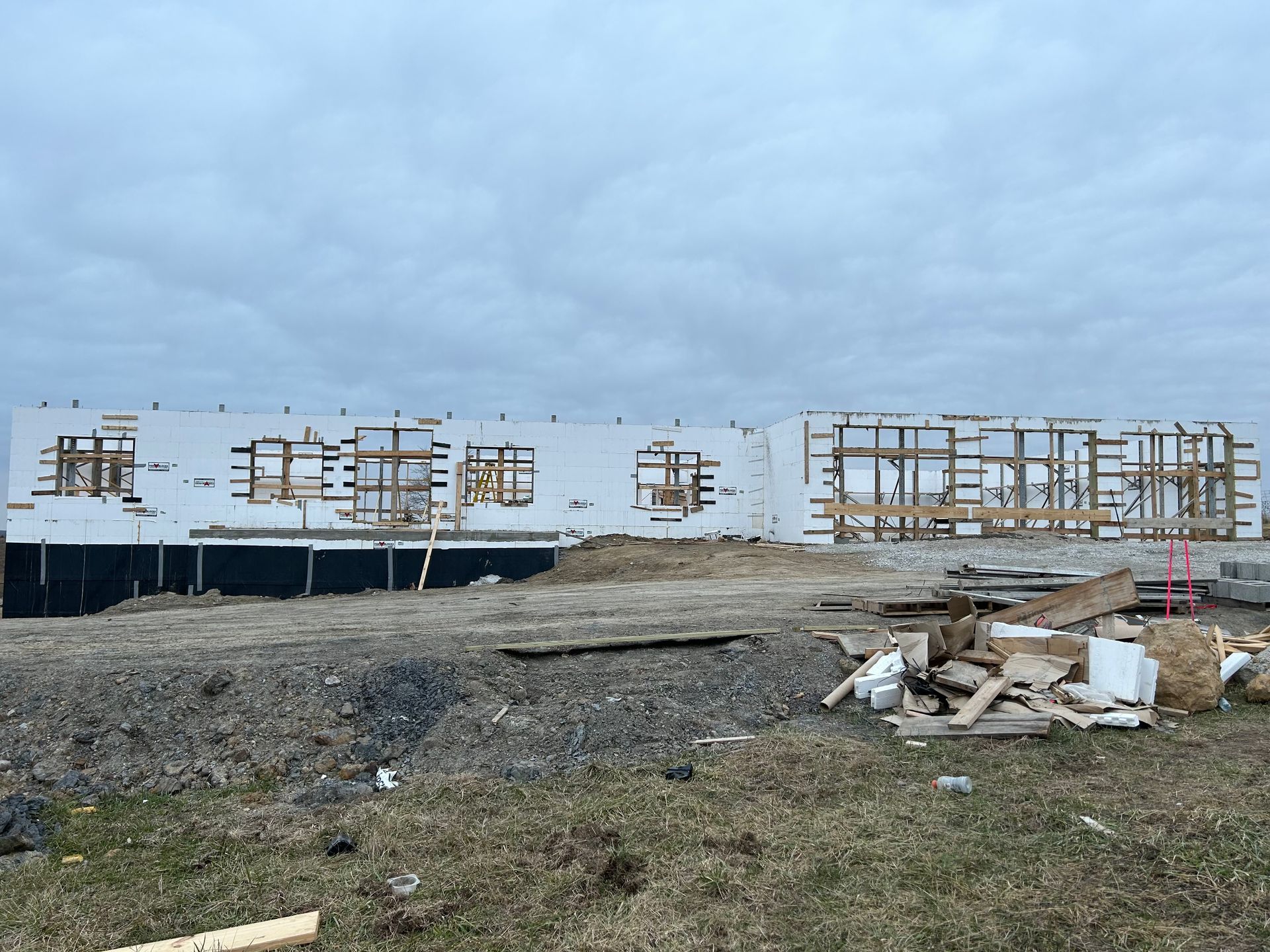 A large building is being built in a field.