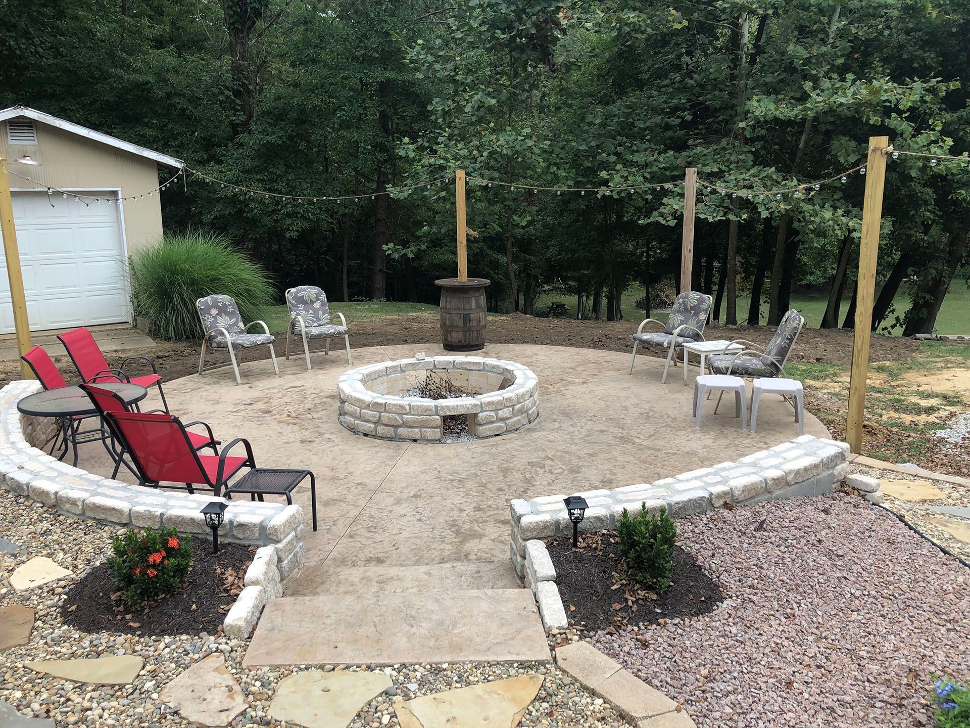 There is a fire pit in the middle of the patio surrounded by chairs.