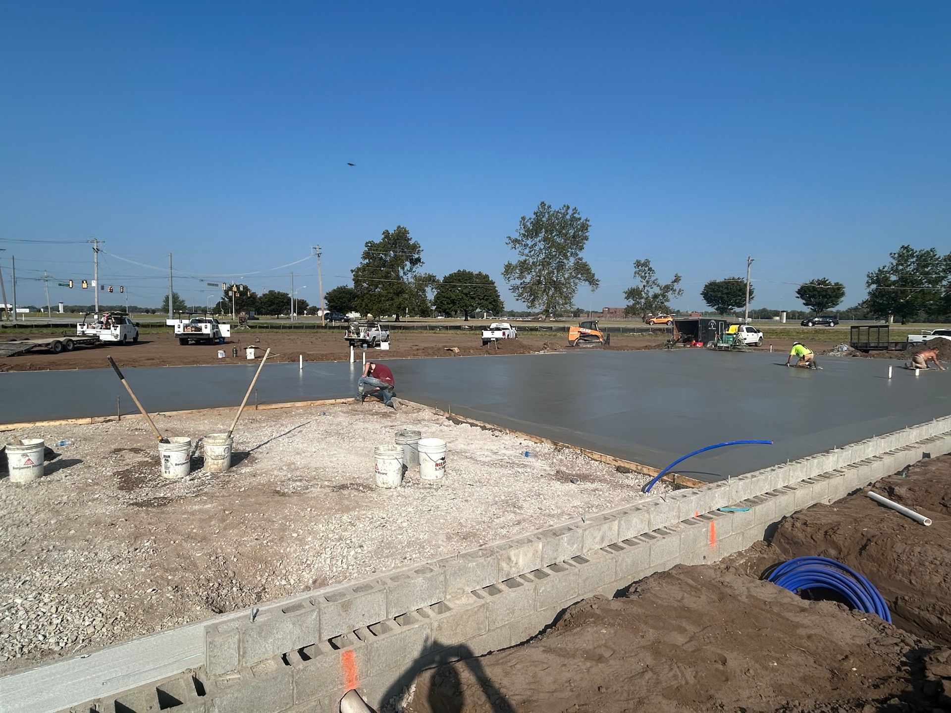 A group of construction workers are working on a concrete floor.