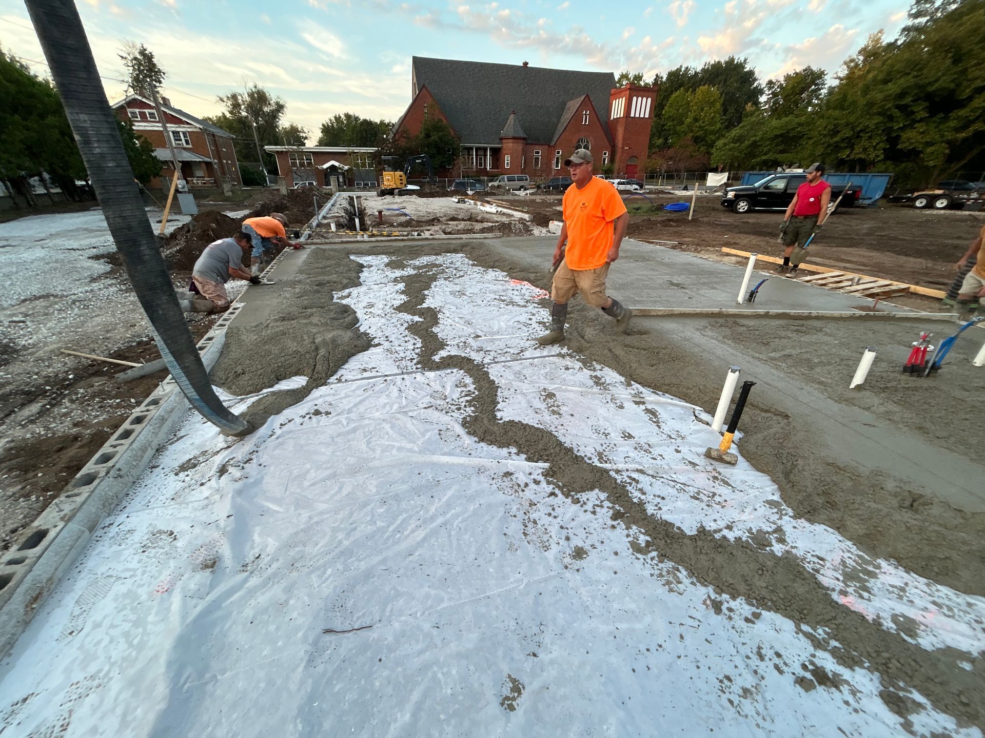 A group of construction workers are working on a concrete floor.