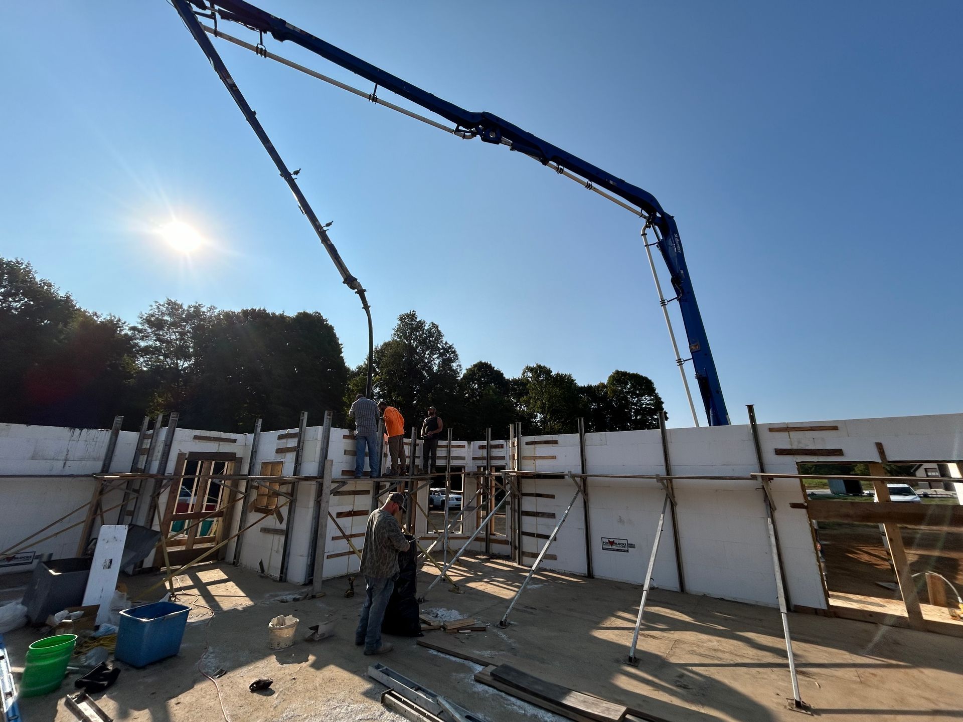 A concrete pump is being used to pour concrete into a building