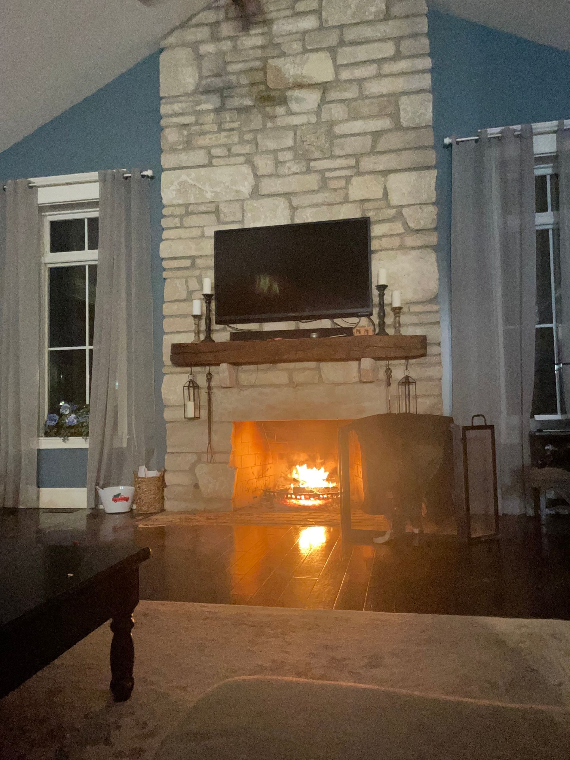 A living room with a fireplace and a flat screen tv