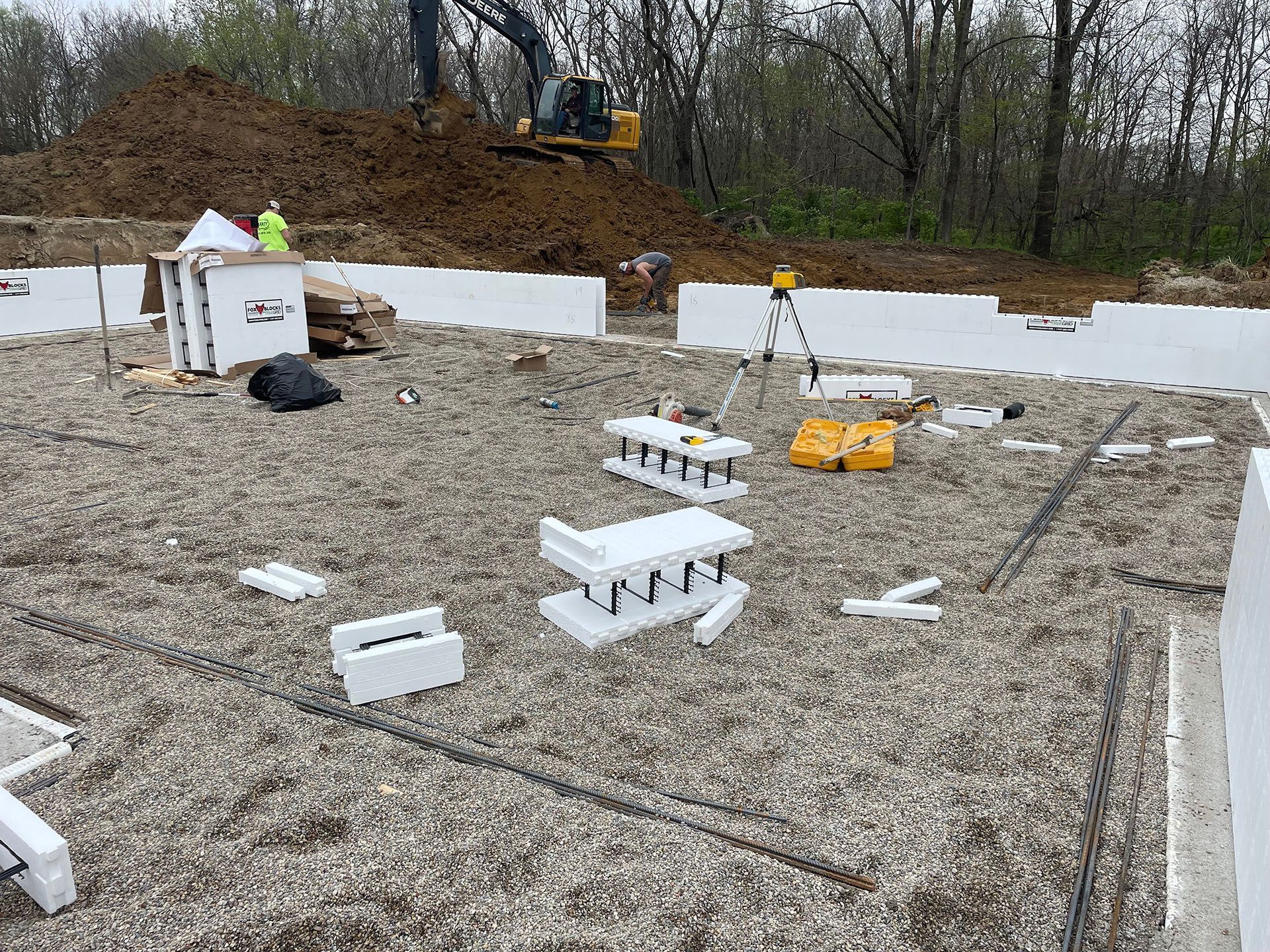 A construction site with a lot of foam blocks and a bulldozer in the background.