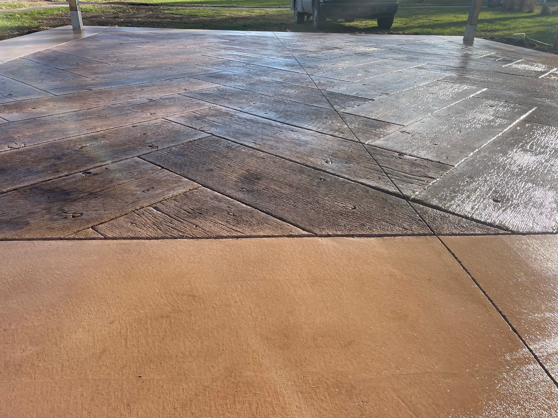 A concrete driveway with a truck parked in the background.