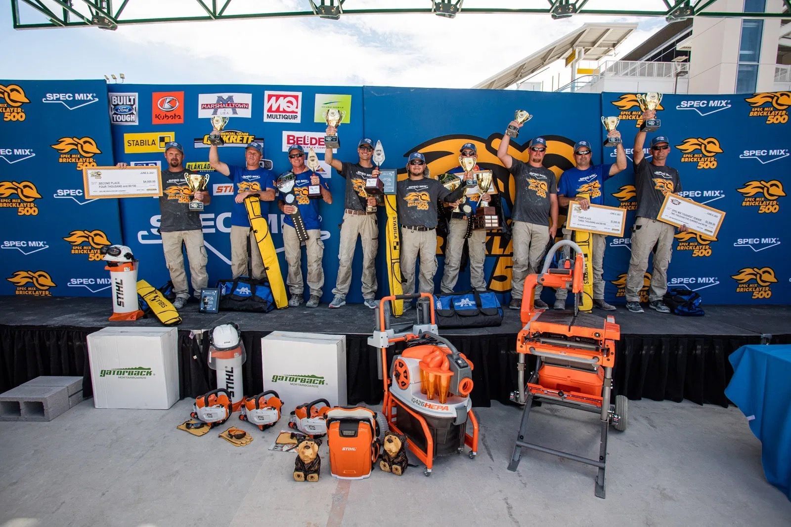 A group of people standing on a stage holding trophies