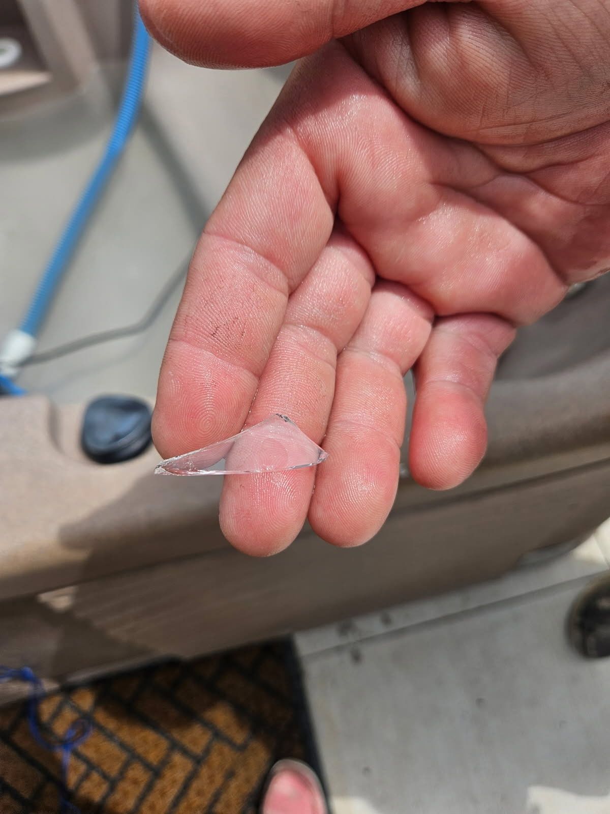 A person is holding a piece of glass between their fingers.