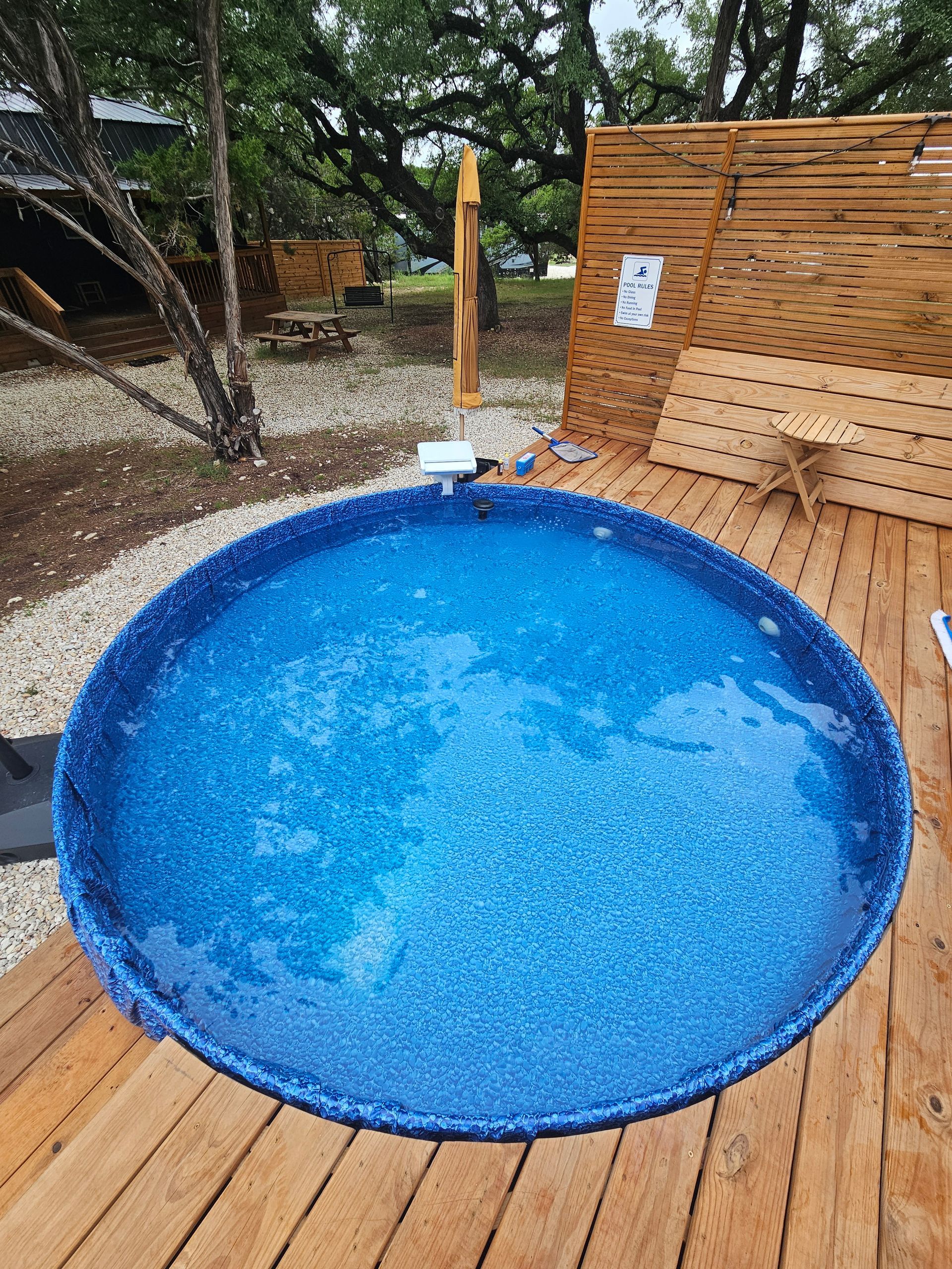 A blue hot tub is sitting on top of a wooden deck.