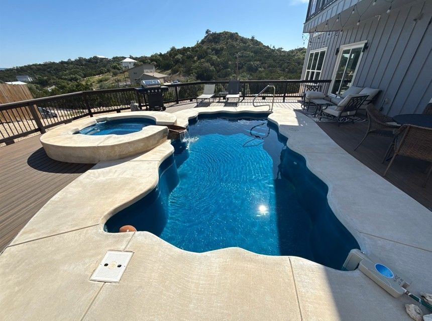 A large swimming pool with a hot tub next to it