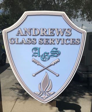 Andrews Glass Services shield logo in silver, light blue, and white with crossed tools and flame emblem.