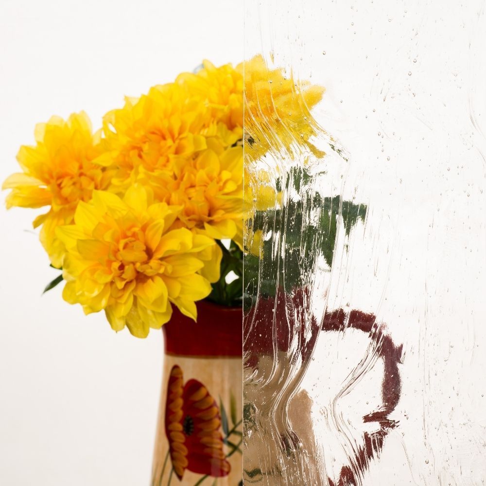 Yellow flowers in a painted vase against a white background