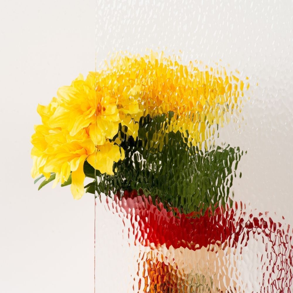 Yellow and red flowers in a vase against a light background