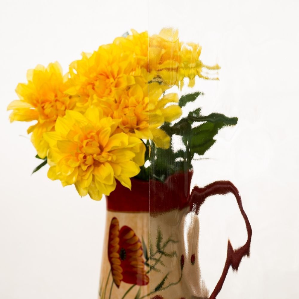 Yellow flowers in a decorative ceramic pitcher on a white background