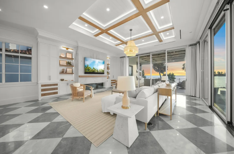 Bright modern living room with white sofas, checkered marble floor, and large windows overlooking water