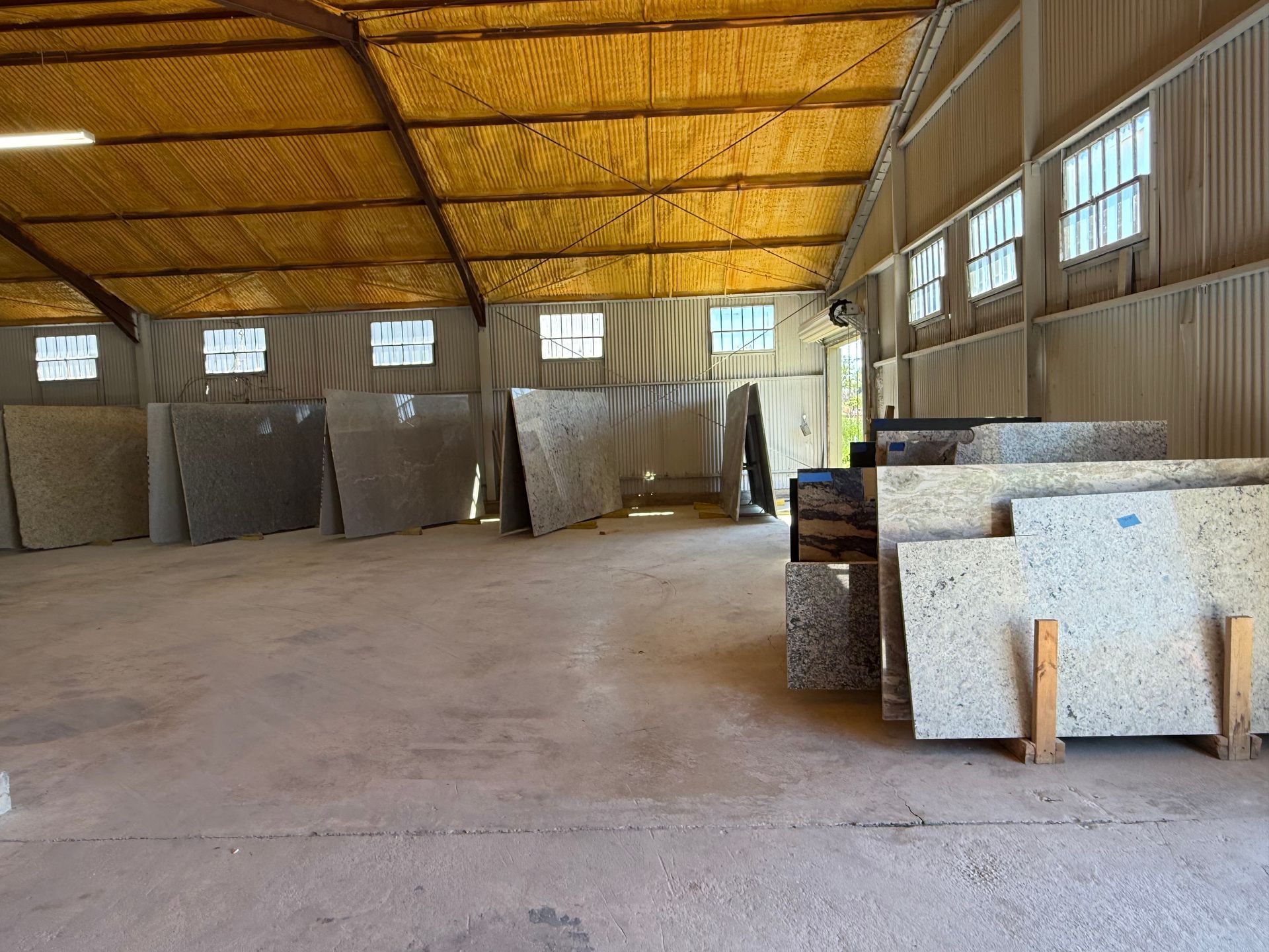 Empty warehouse interior with stacked materials and a yellow insulated ceiling