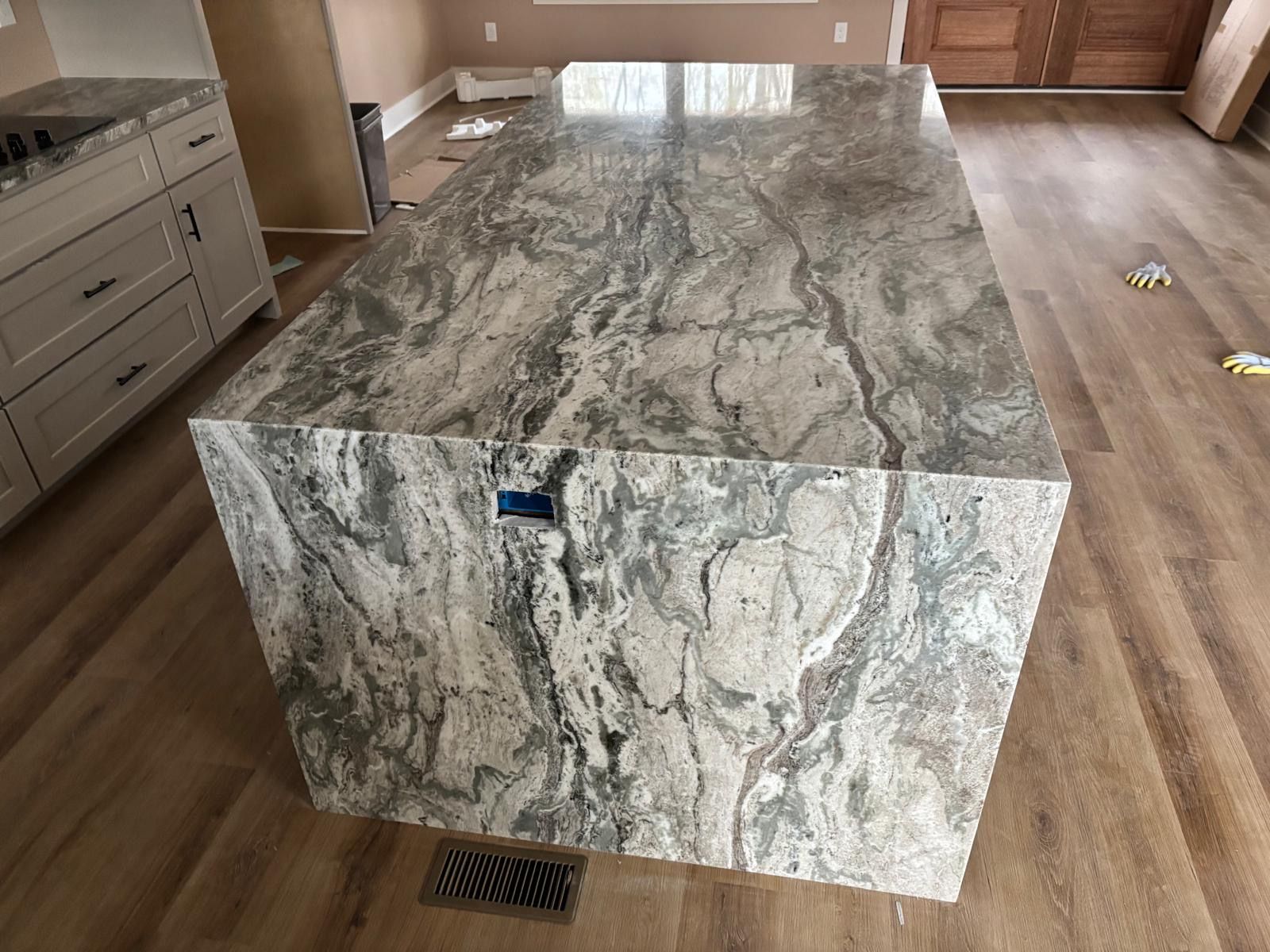 Large marble kitchen island with gray veining in a modern room
