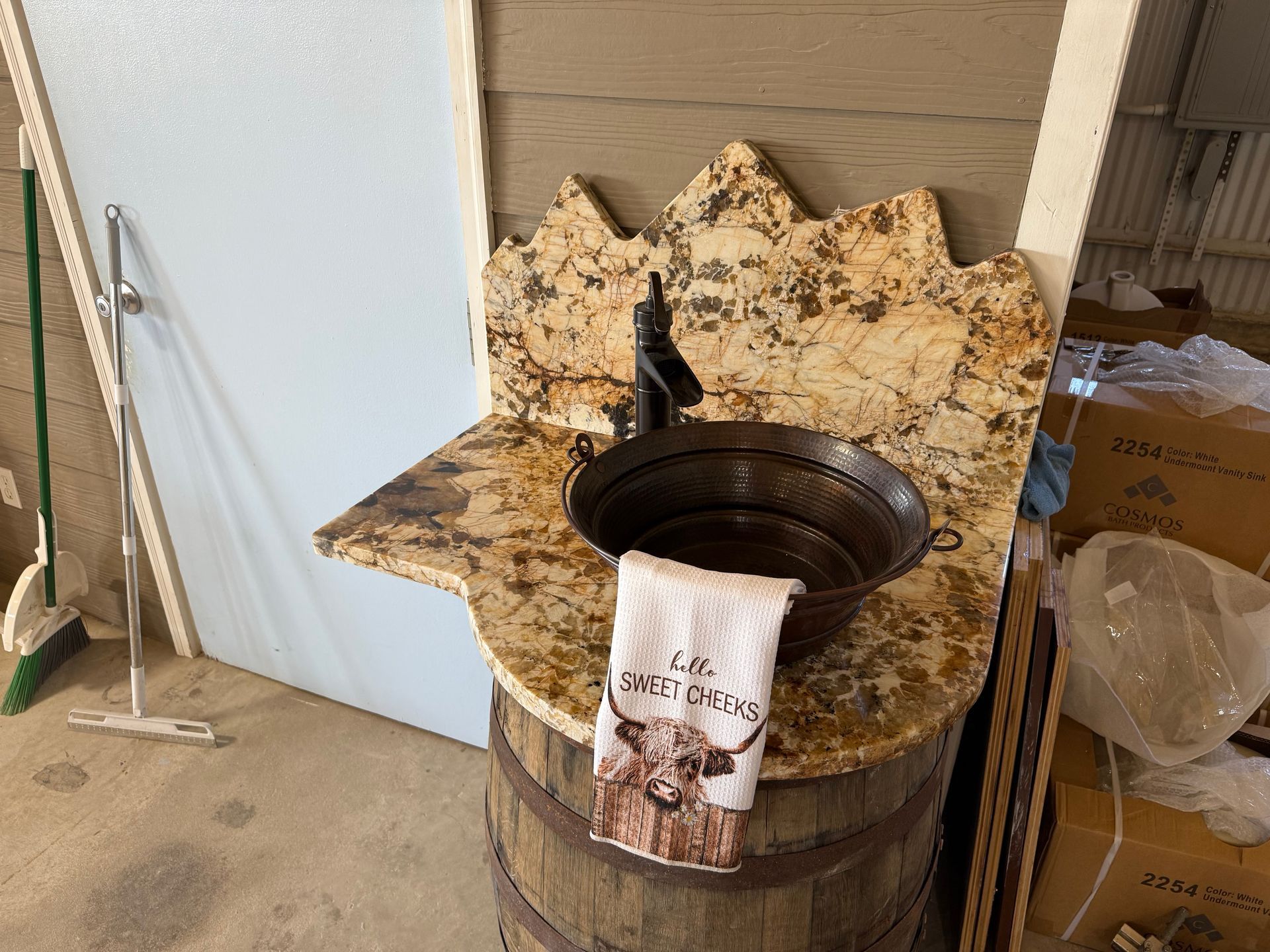Floral pet bed beside a black metal planter in a garage or storage area