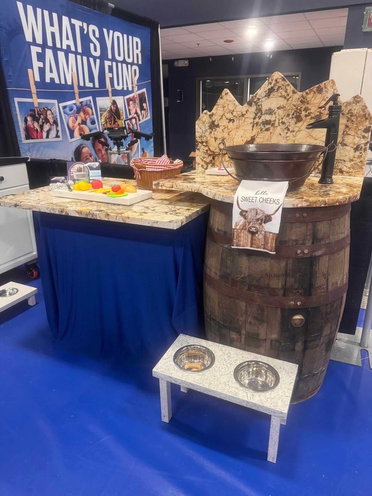 Display booth with food table, banner reading “What’s your family fav?”, and large BBQ smoker setup