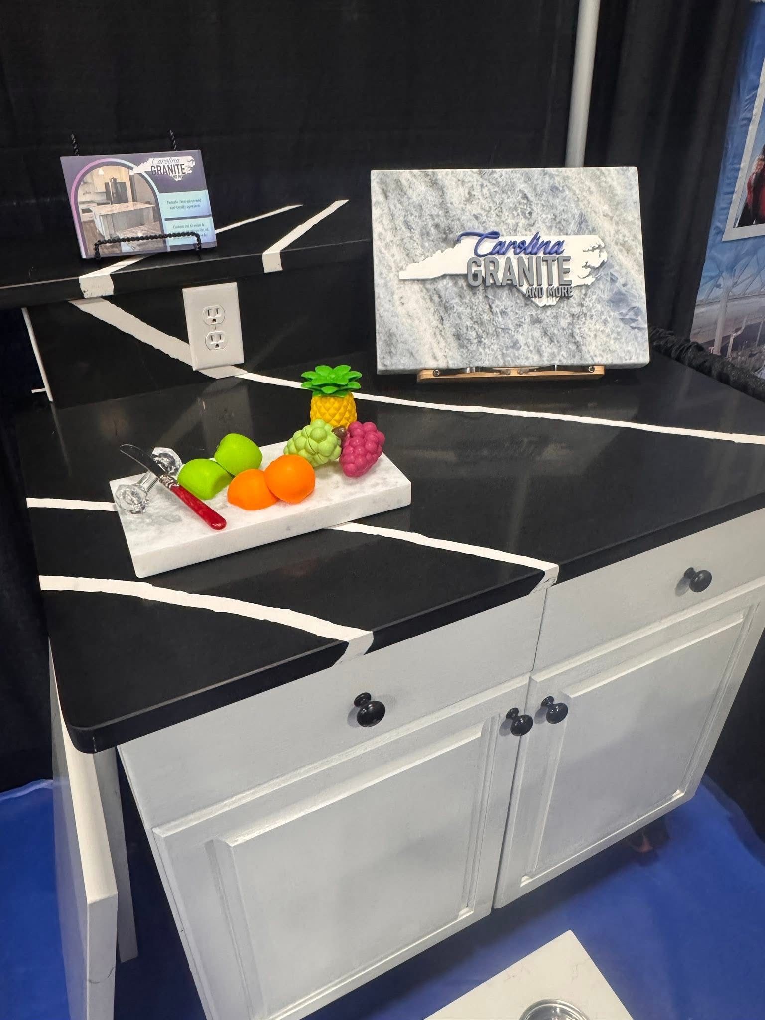 Display cabinet with black shelves, white cabinetry, candy prop, and two product boxes on top shelves