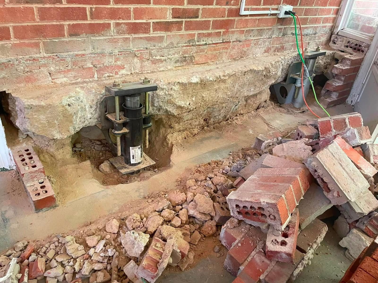Collapsed brick wall with excavation supports and rubble in a damaged building site