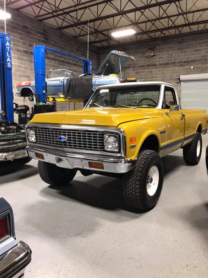a red Chevy pickup truck parked in front of a brick building