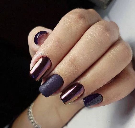 Hand with dark purple nails, some matte, some chrome finish.