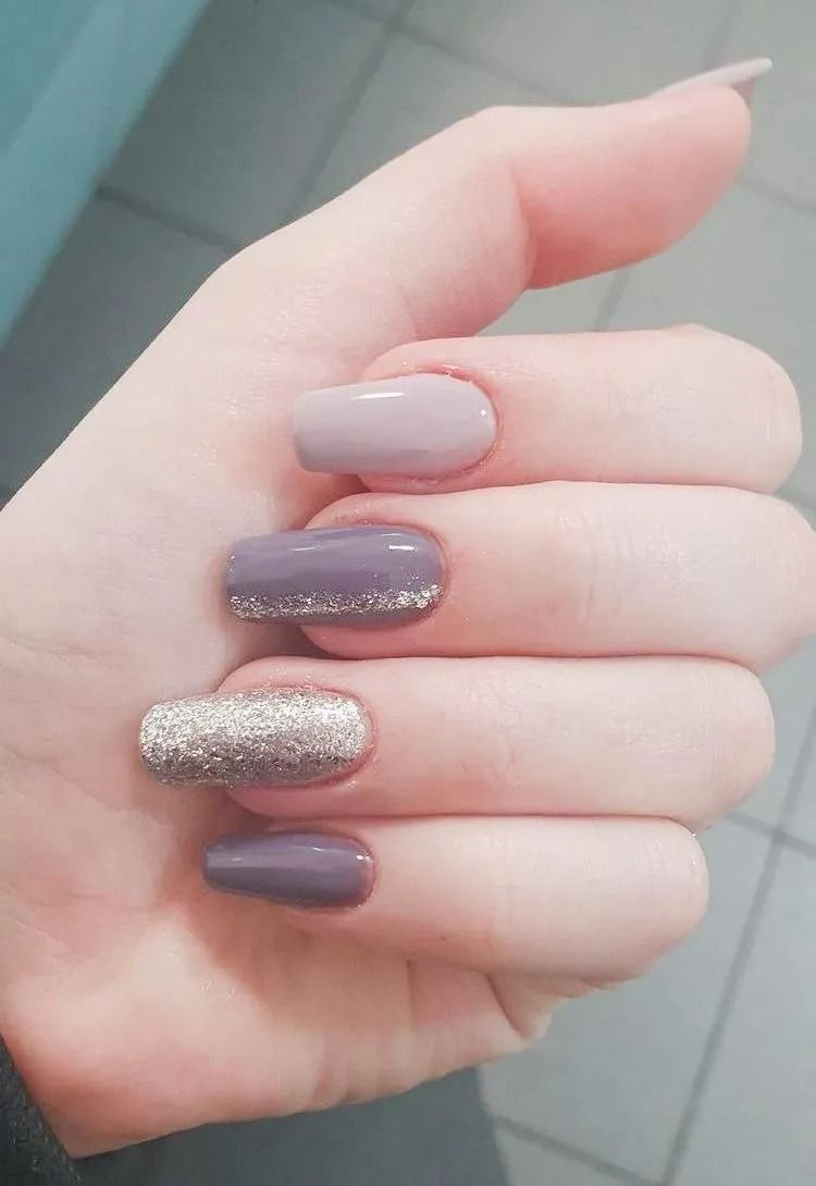 Hand with four nails painted purple, silver glitter accent on one nail.