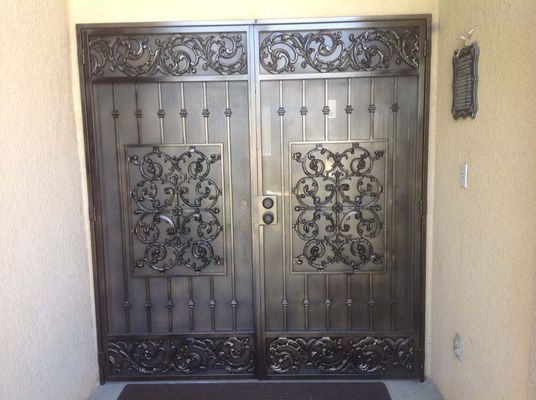 Ornate, dark metal double doors with decorative scrollwork.