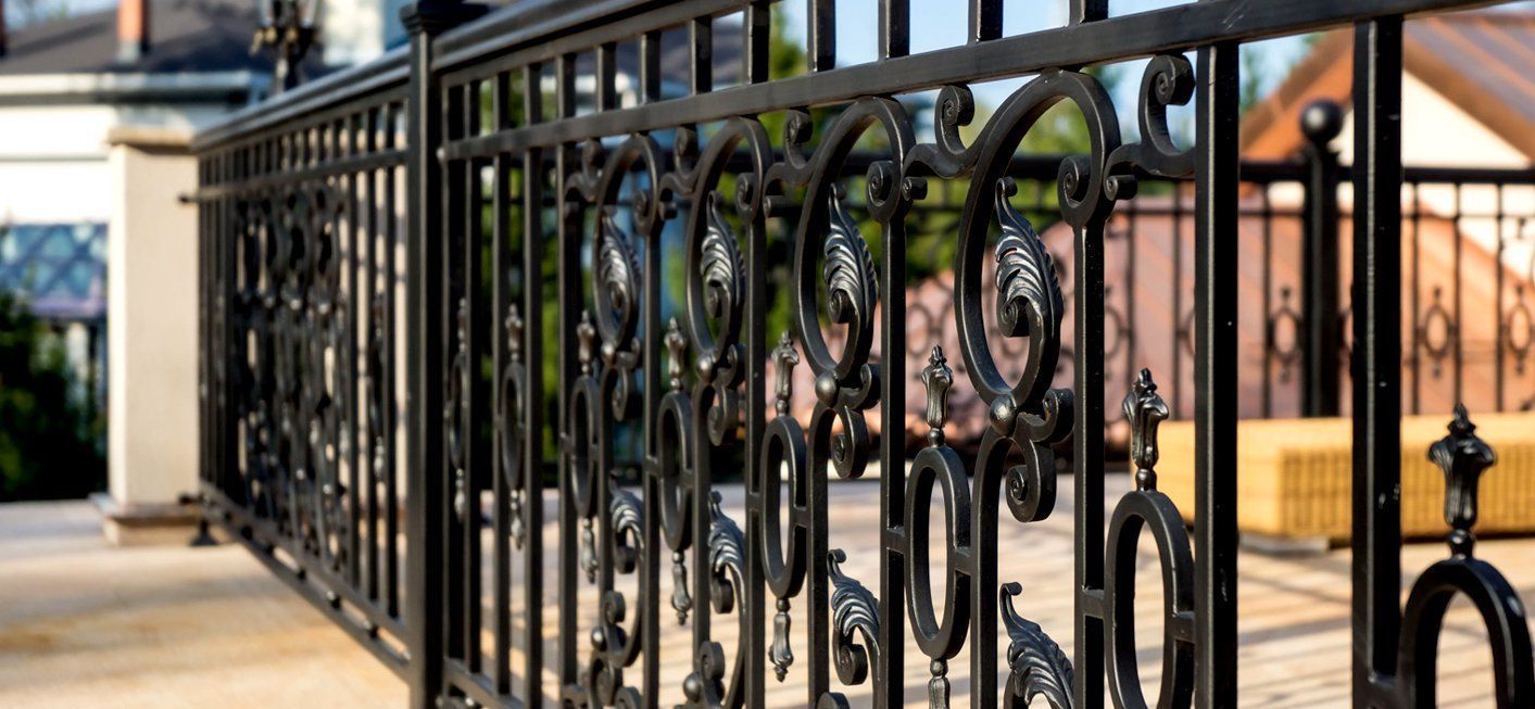 Black decorative wrought iron railing on a terrace.