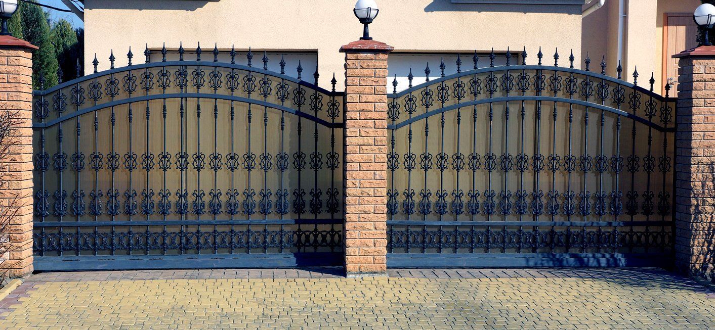 Ornate wrought iron gate with brick pillars.