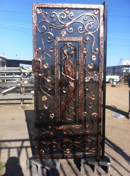 Ornate metal gate with copper accents and peacock design.
