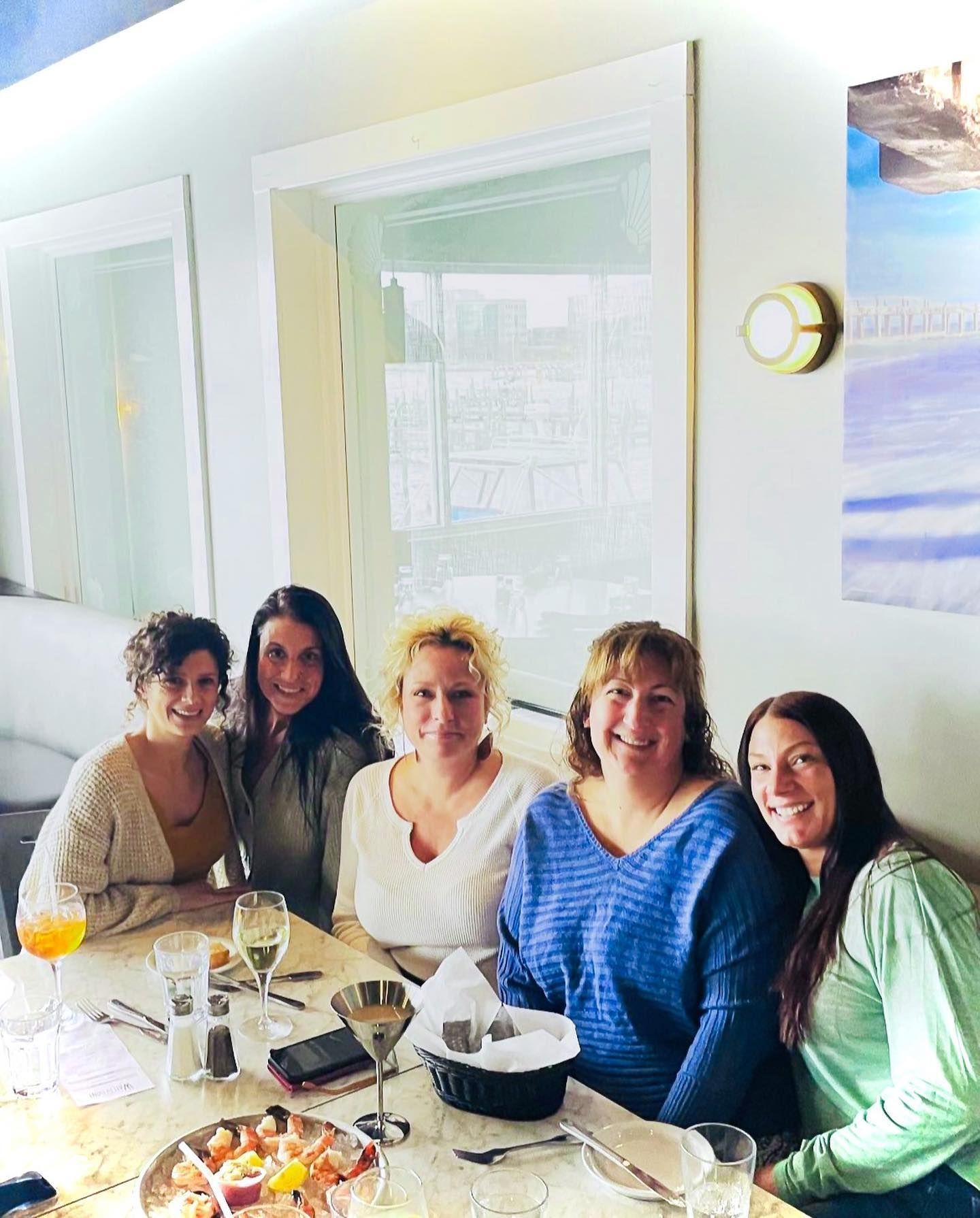 Five women seated at a table in a restaurant.