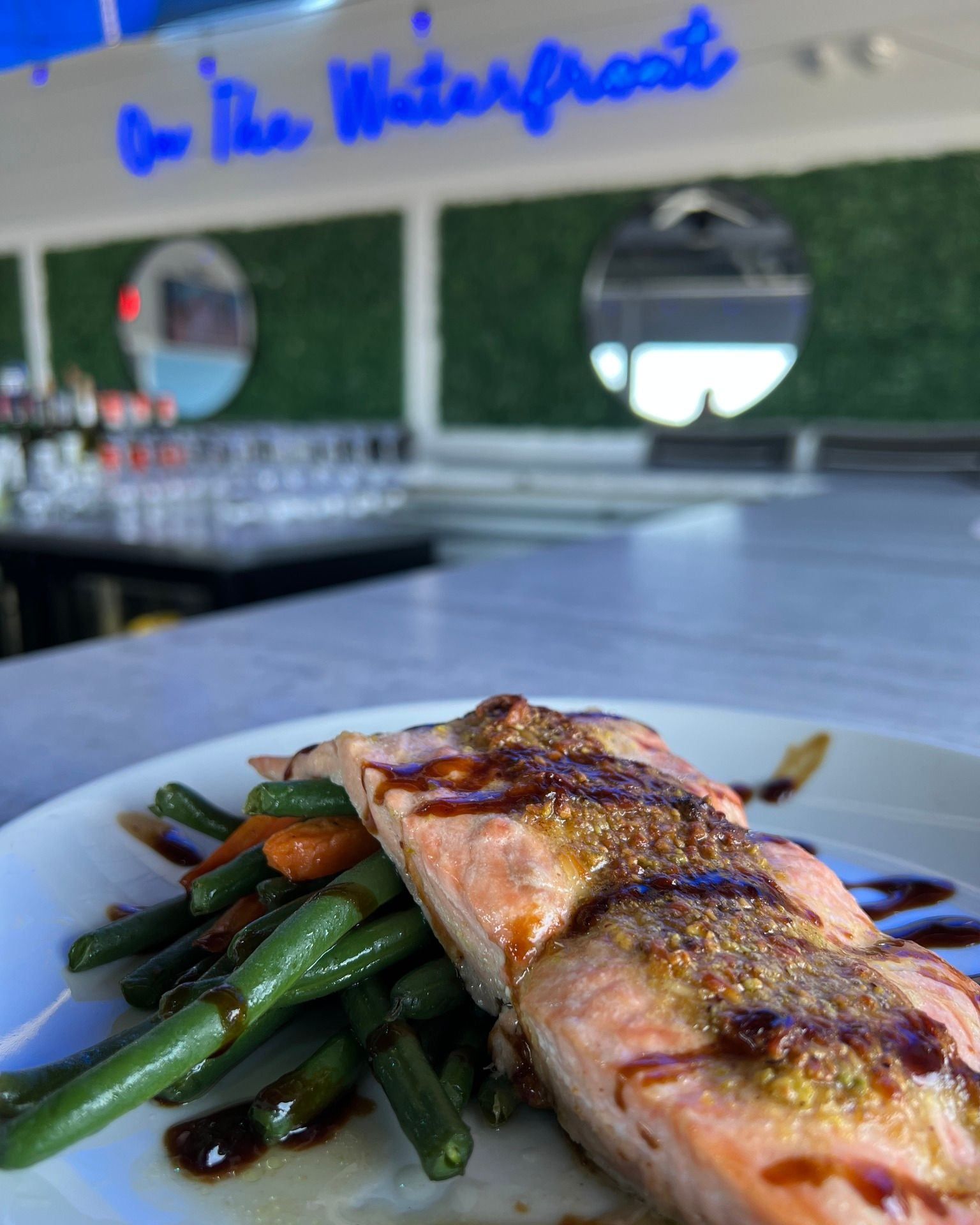 Salmon filet with vegetables, served on a white plate.