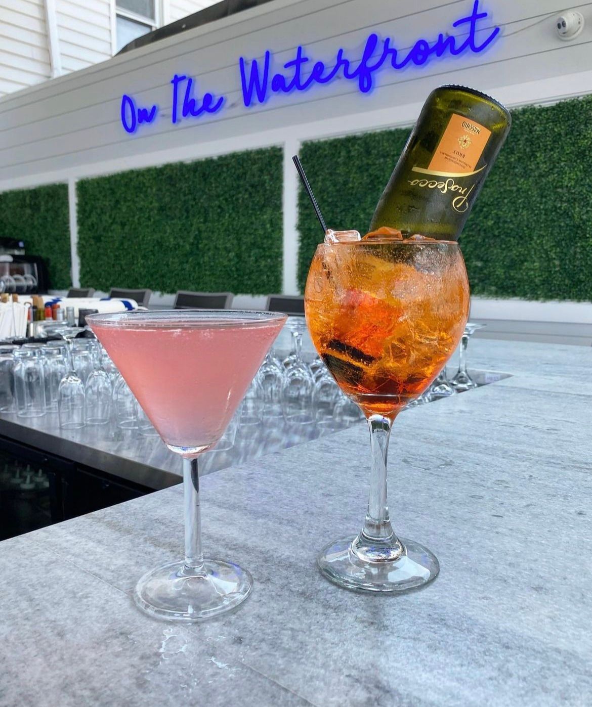 Two cocktails on a bar.