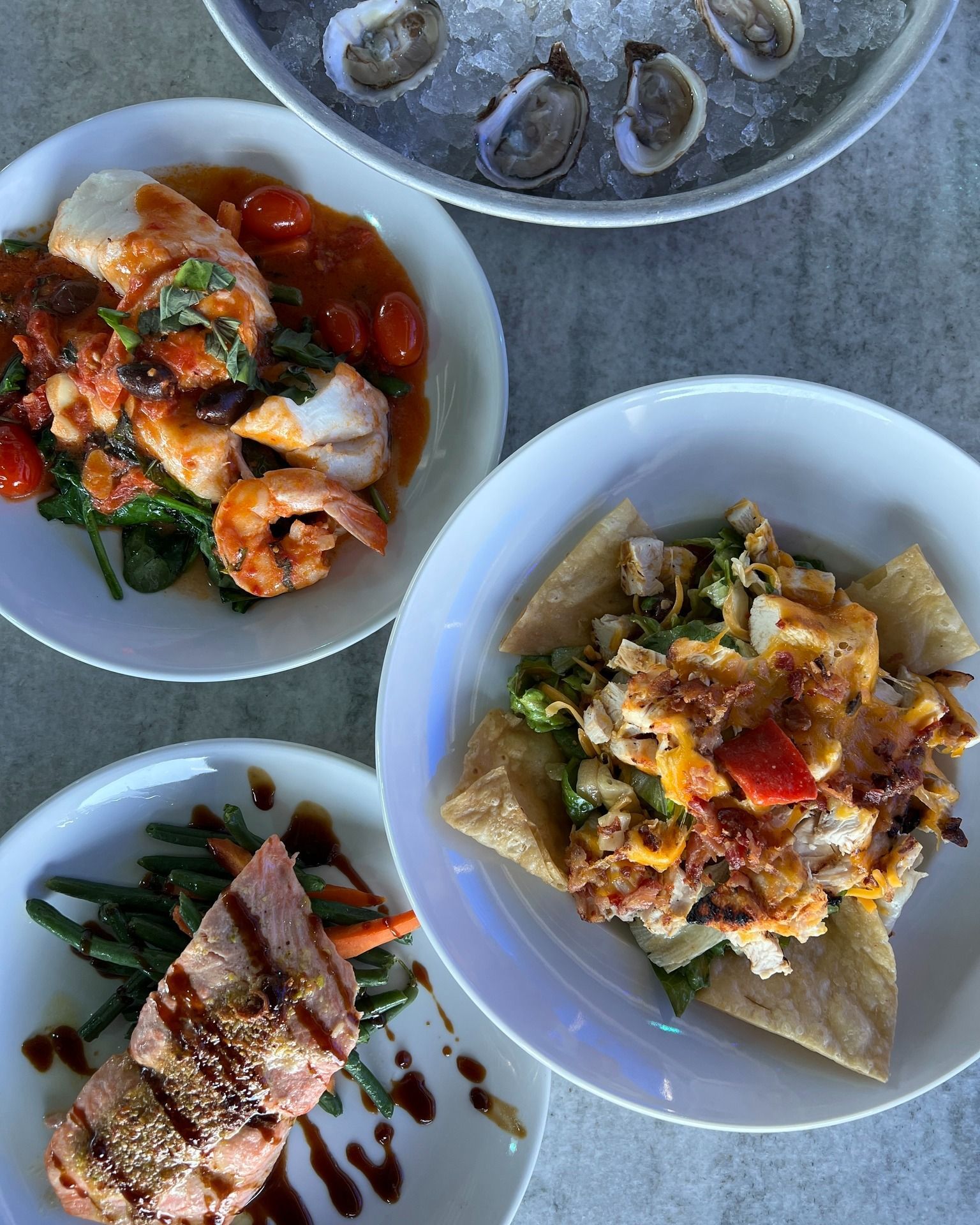 Assorted seafood dishes on white plates.