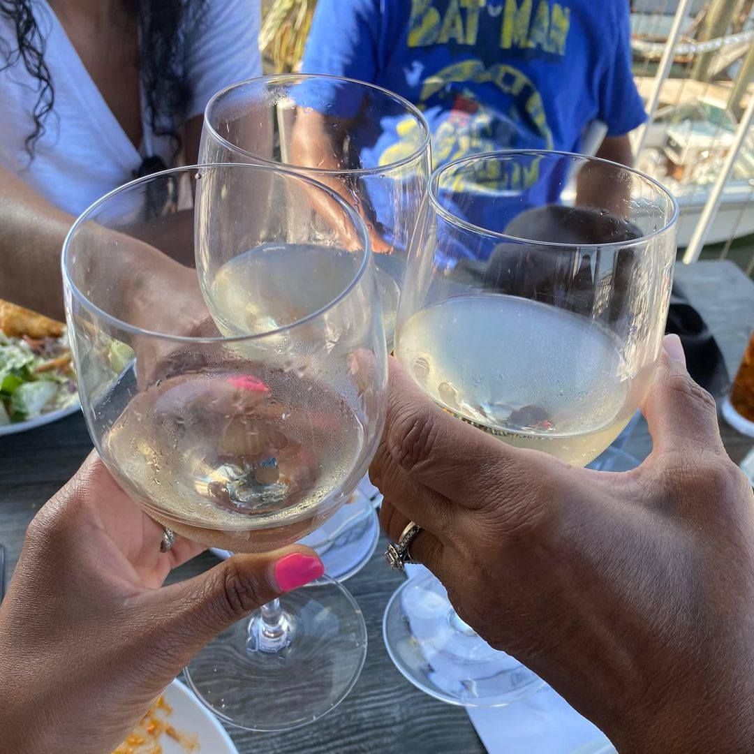 People toasting with wine glasses outdoors.
