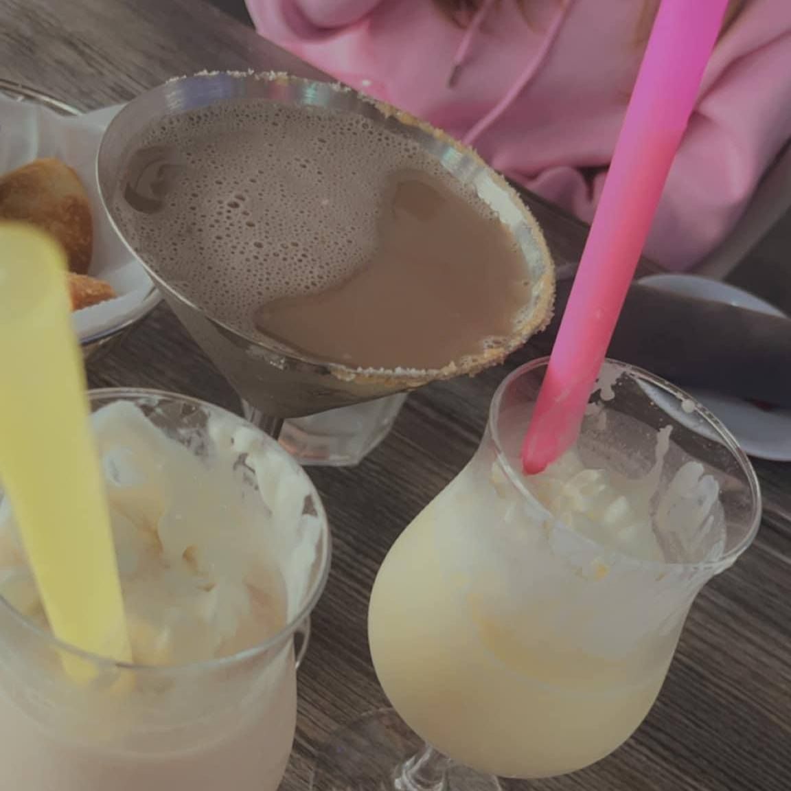 Three cocktails with colorful straws.