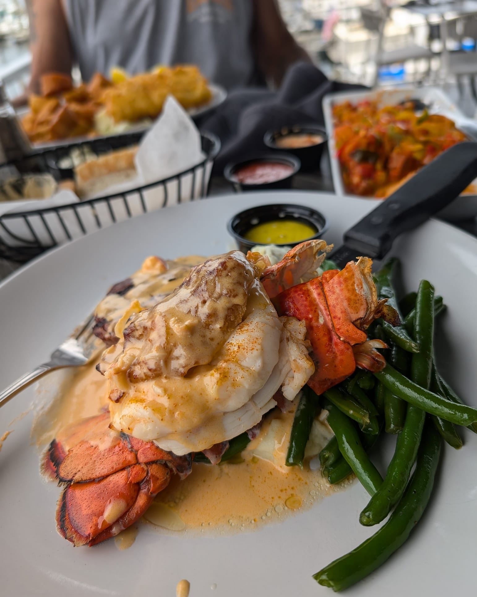 Lobster tail and green beans on a plate.