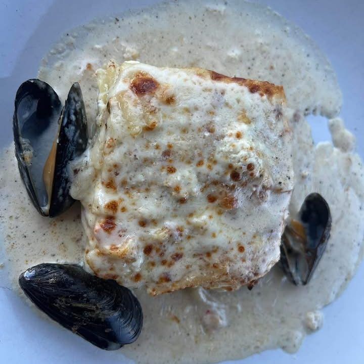 Baked seafood dish with creamy sauce and mussels.
