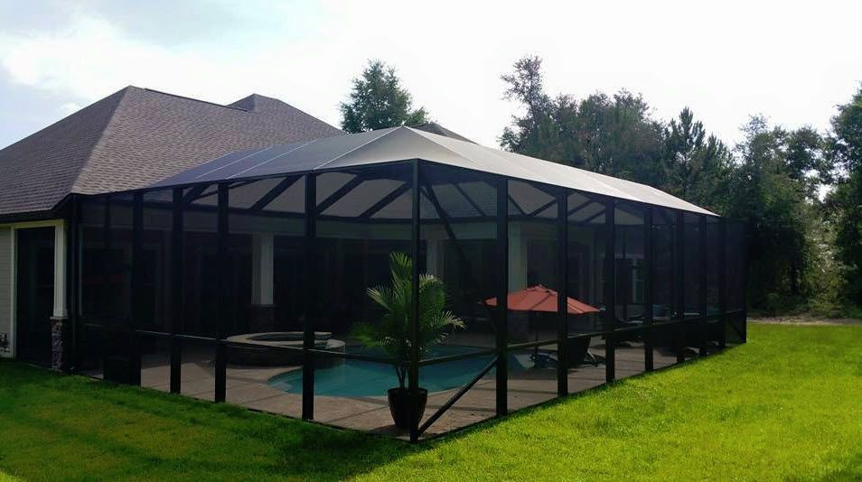 Screened backyard patio with pool, red umbrella, and potted plant beside a house