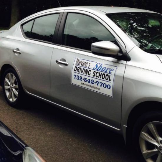 Silver car with Marianne's Shore Driving School on the door.