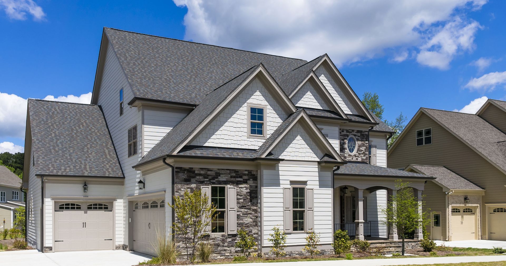 A man in a yellow vest is working on a roof.