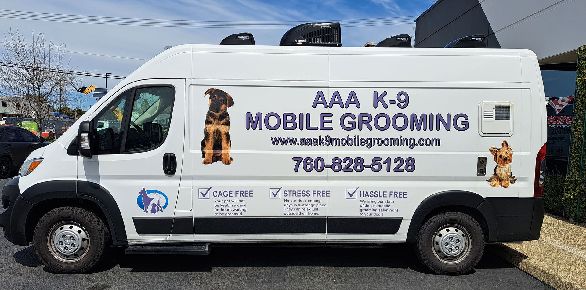 White van with “AAA K-9 Mobile Grooming” branding parked outdoors on a sunny street.