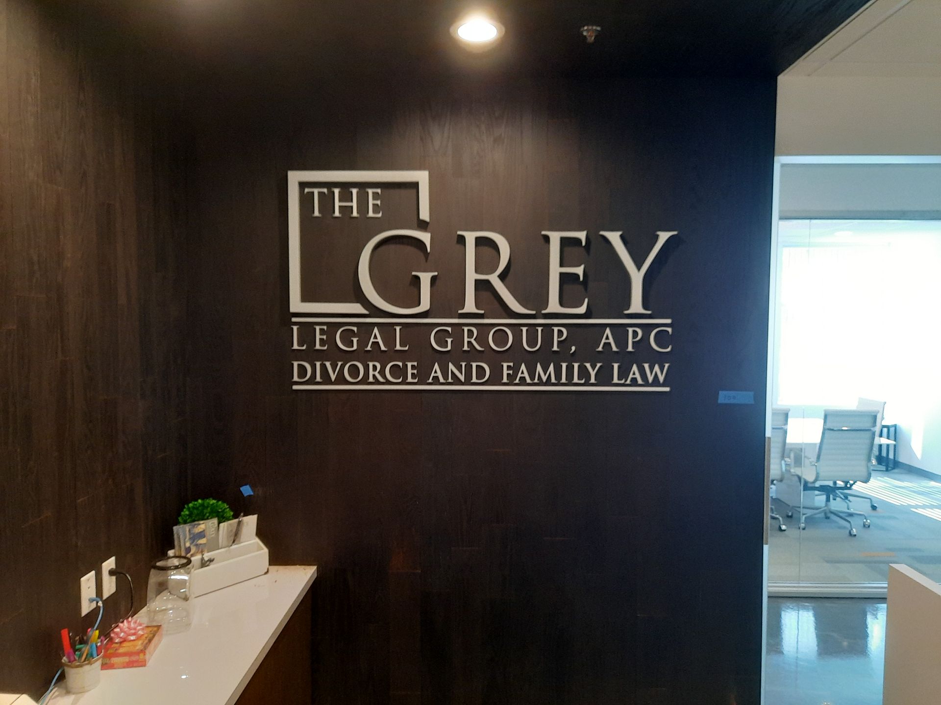 Office wall sign for The Grey Legal Group, APC, Divorce and Family Law, in a dark hallway