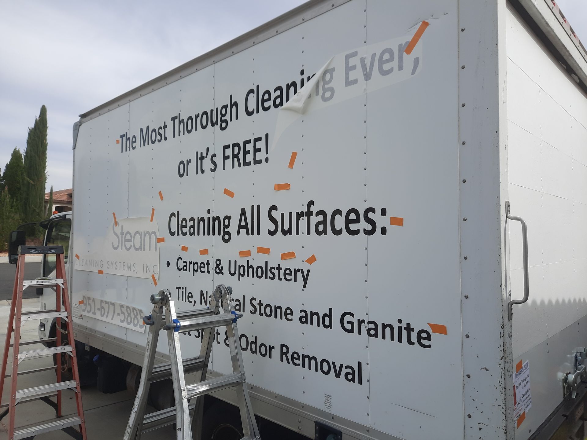 Cleaning service truck with ladder and large exterior ad for carpet, upholstery, tile, and odor removal