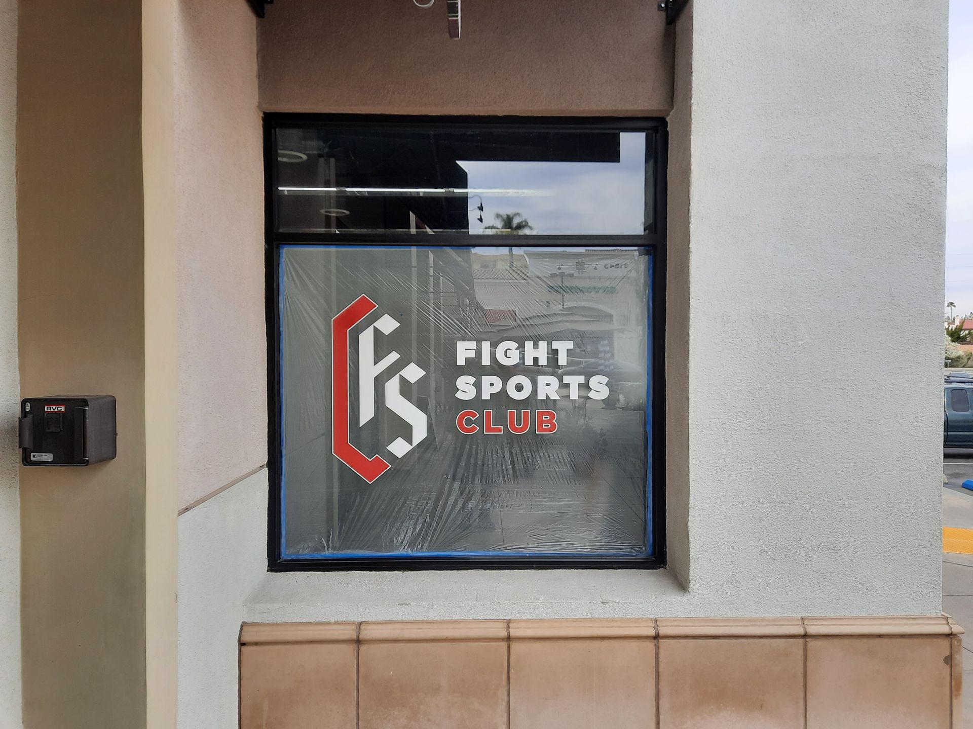Fight Sports Club sign in a storefront window with a red and white logo