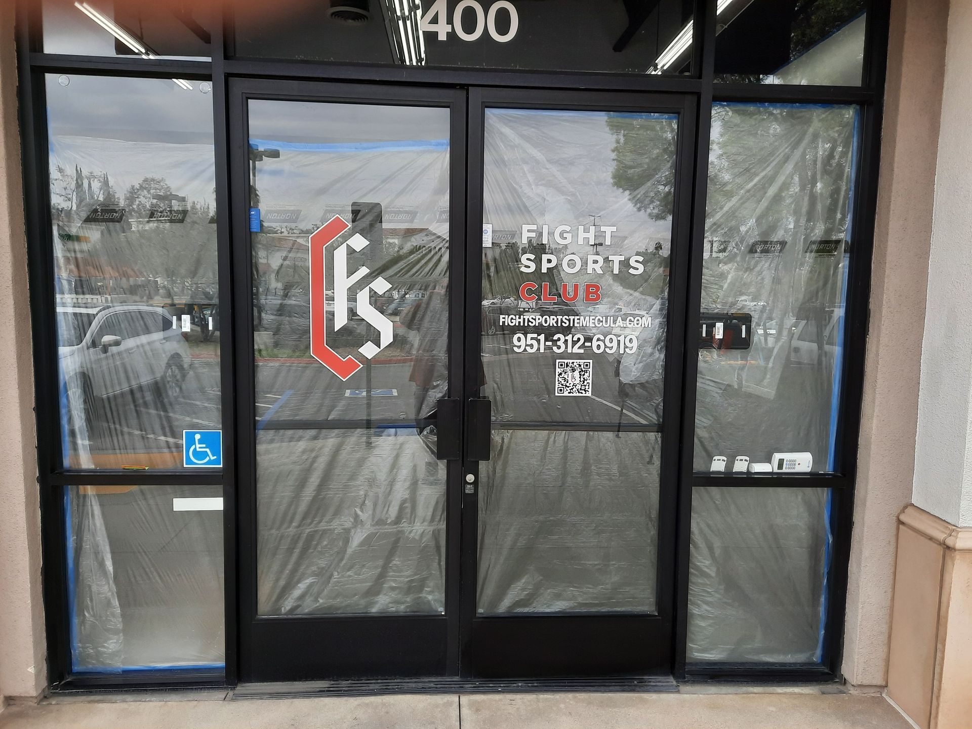 Storefront entrance with glass doors and windows, marked “Eagle Sports” with phone number and logo