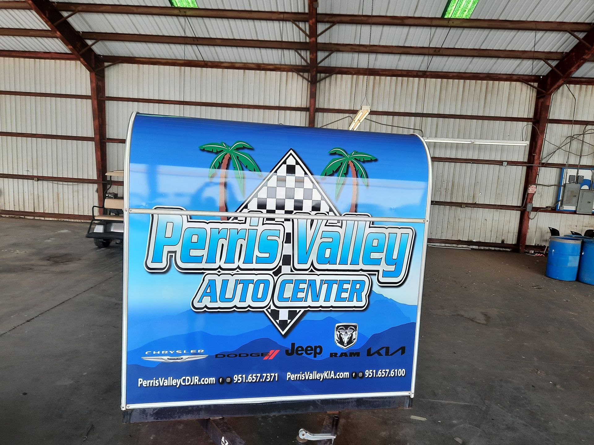 Ferris Valley Auto Center blue sign with palm trees in a covered warehouse-like space