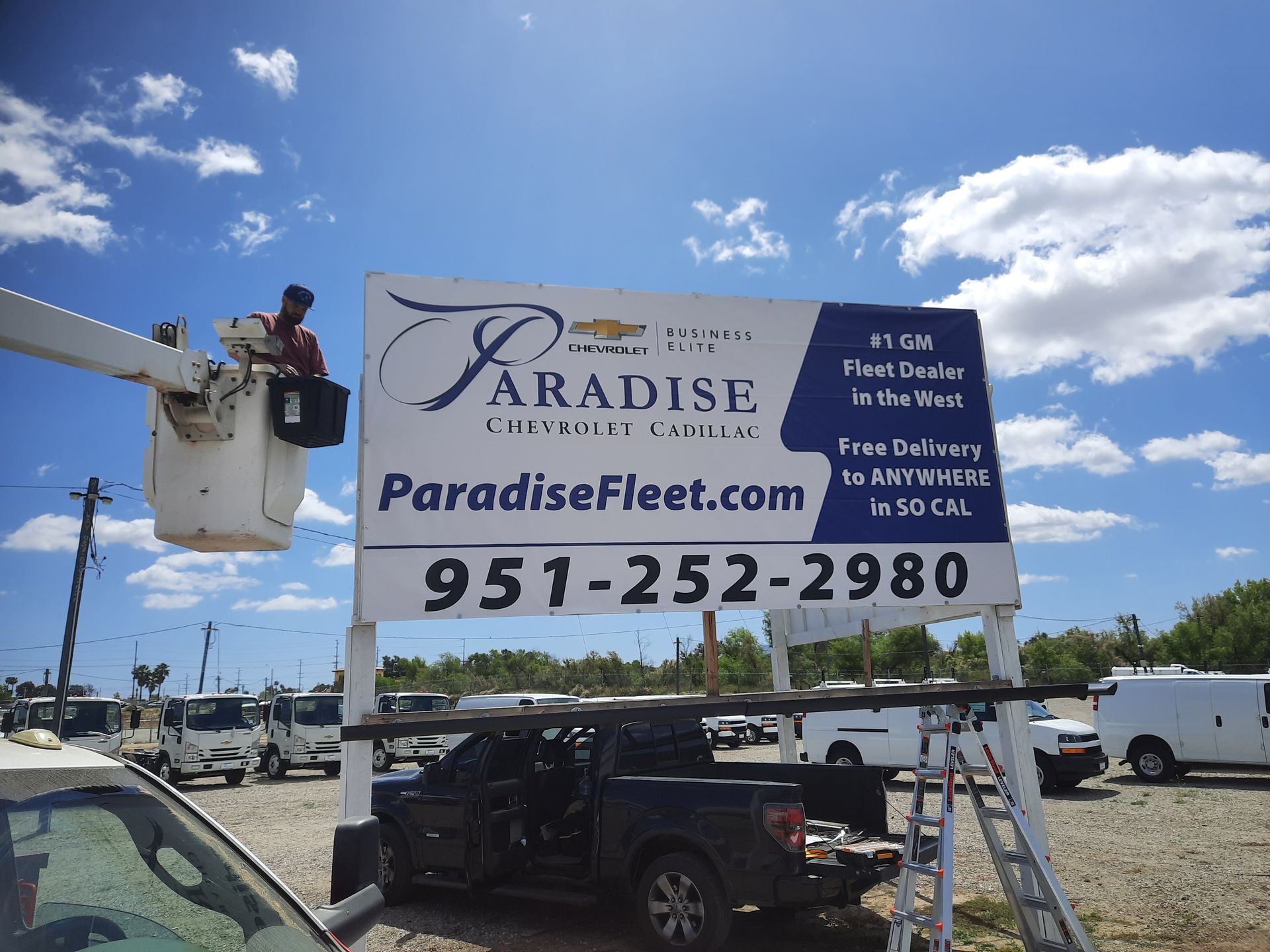 Billboard for Paradise Fleet with phone number and boat lift services under a blue sky.