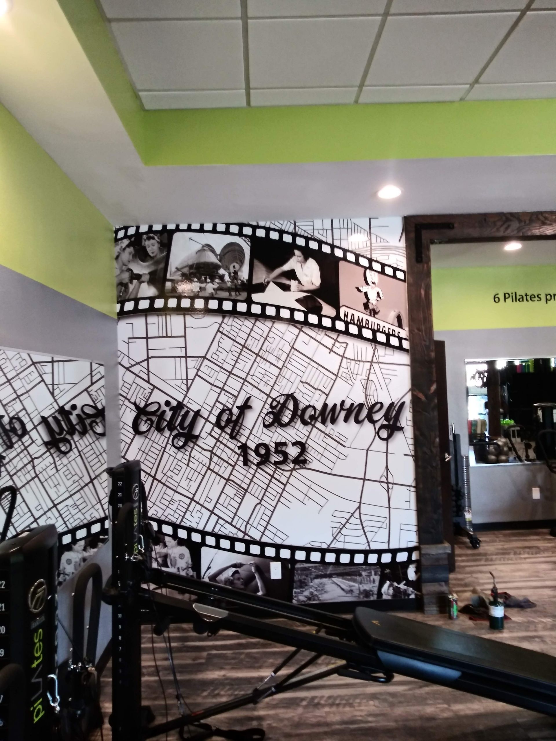 Gym interior with a large black-and-white “Built to Grow 1952” mural and exercise equipment